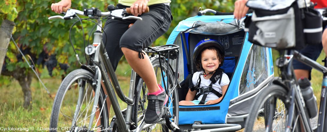 Enfant dans une cariole accrochée à un vélo